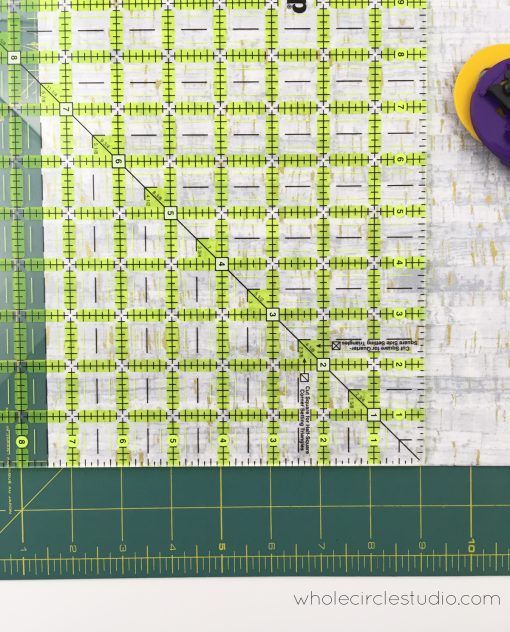 Squaring up and trimming fabric for a quilt.
