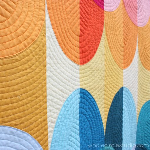 detail of Kona Sunset, a modern curve Drunkard's Path quilt using solid fabrics. Inspired by Hawaiian sunsets on the Big Island in Kona. Design by Sheri Cifaldi-Morrill of Whole Circle Studio.