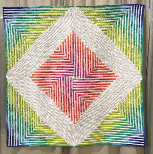 Modern quilt featured at QuiltCon 2019 — “Star Sprinkles” by Steph Skardal www.instagram.com/stephskardal Statement: “This original design was created in Photoshop. It is the first in a series of quilts taking inspiration from the blending of watercolor paint in a bright, modern color palette mixed with the hardness of geometric (linear) shapes. The modified courthouse steps form a larger diamond shape via negative space. It was machine quilted on a domestic machine using a walking foot.