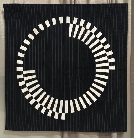 Modern quilt featured at QuiltCon 2019 — “Offset” by Audrey Esarey @cottonandbourbon Statement: “Offset is an original design. I wanted to explore a design based on one large circle and two high contrast fabrics. I love how the black and white wedges are perfectly offset creating segments that fit together, but do not touch each other. I omitted one wedge of each circle in different areas so the visual weight is balanced. This quilt was designed using EQ8, paper pieced, machine pieced and machine quilted. I used a facing to finish the edges of the quilt.”