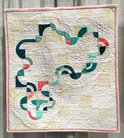 Modern quilt featured at QuiltCon 2019 — “Amoeba” by Heather Shields @heathersaysew Statement: “Each of the arcs were cut freehand and then hand appliquéd onto 2.5” squares, a technique I learned from Nydia Kehnle. I then improv-pieced the squares together in my own design to create a continuous loop which required partial seams in some areas. The pice is hand quilted using 12wt thread and pearl cotton.” Source: Nydia Kehnle workshop