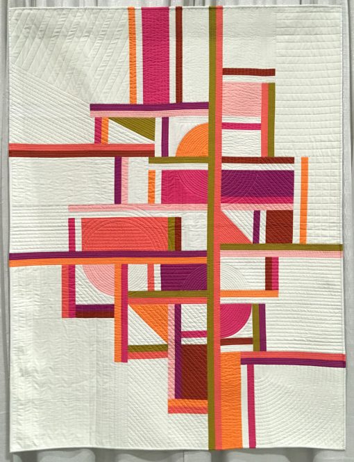 Modern quilt featured at QuiltCon 2019 — “Geometry Lesson” by Jayne Willis @twiggyandopal Statement: “This quilt was inspired and designed specifically for this color palette. The colors were influenced by a recent trip to ‘Lauderdale by the Sea’ with my daughter. The colors engulf you with a relaxing warmth that only a tropical setting in winter could! Getting all the parts and pieces of the geometric shapes to intermix in a cohesive design was my main focus. Showcasing the color palette was also a big factor in my design.”