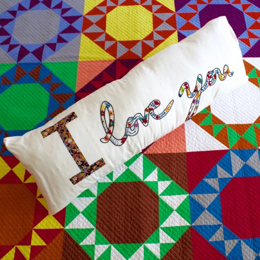 English Paper Pieced letter block (EPP) in a pillow with hand embroidery made by Kim Soper of Leland Ave Studios. Made with Liberty of London Fabric and Typecast EPP pattern. 