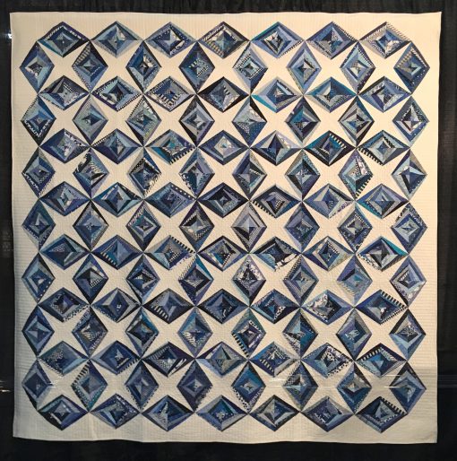 Ice Crystals by Cheryl Degan. Quilted by Emily Bowers. This was my first ever string pieced quilt. I love this quilt because it reminds me of the fun I had sewing with my dear friends on a weekend quilting retreat. | Techniques: Machine pieced and quilted. | Design Source: Images on Pinterest | Photo taken at 2019 International Quilt Festival