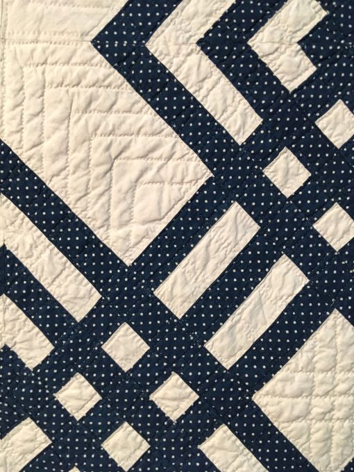 detail of Carpenter's Square by Unknown Maker. An indigo and white Carpenter's Square is distinguished by an unusual diagonal block. Constructed by hand and machine, the quilt features double line hand quilting in a windowpane pattern with a hand stitched binding. On loan from the collection of International Quilt Festival. | Techniques: Hand pieced and quilted, machine pieced | Design Source: Interlocked Squares | Photo taken at 2019 International Quilt Festival