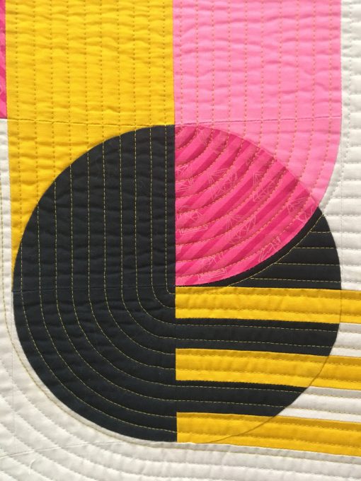 detail of “Bubble Gum” by Sophie Zaugg @lunalovequilts Awarded 2nd place in Use of Negative Space category Statement: “The design was inspired by a geometric street art mural. I included the main motif in negative space to showcase it and mimic the concrete wall of the original work. I placed the yellow strips as if they linked the motif to the edge of the quilt. All the curves are hand appliquéd.” Modern quilt featured in the Use of Negative Space category at QuiltCon 2020 in Austin, Texas presented by the Modern Quilt Guild.