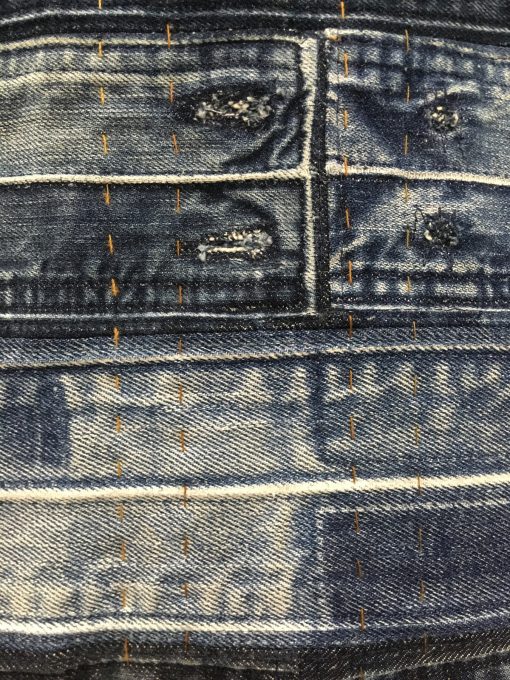 detail of “Waist Not” by Eliu Hernandez @madeorremade Statement: “Waist Not, not only a play on words, but also a play in practice. Denim waistbands, batting and backing have been reclaimed. The thread has also been reclaimed from jeans. The hand-quilting highlights the harvested thread. Textile waste is a huge contributors to landfills—Waist Not shows that there is beauty and fiction in what many consider trash.” Modern quilt featured in the Quilting Challenge category at QuiltCon 2020 in Austin, Texas presented by the Modern Quilt Guild.