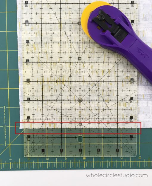 Squaring up and trimming fabric for a quilt.
