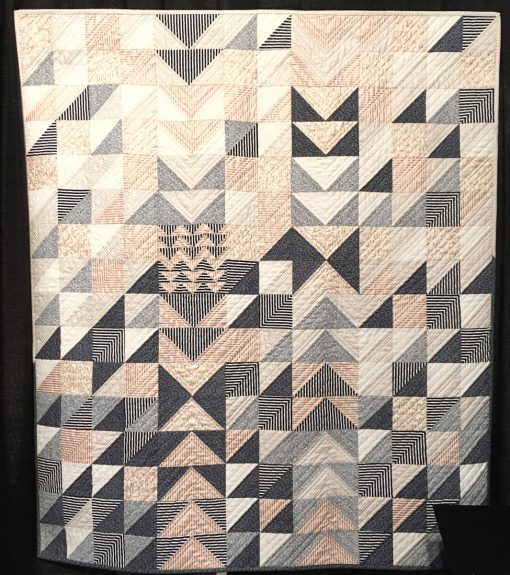 "Net Worth" by Sarah Lefebvre Statement: "This quilt was an entry in the Riley Blake Designs Spring 2018 Fabric Challenge. Titled literally because the middle part of the quilt top and quilting design reminded me of the "net worth" emoji. Titled figuratively because although it is complete, it is not perfect. We all need to remind ourselves that our perfectionism in quilts and in life, or lack thereof, does not equate to our personal net worth!" [Design Source: Half-square traingles, Flying Geese blocks] sponsored by the Modern Quilt Guild at the International Quilt Festival in Houston