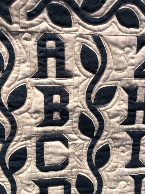 detail of Alphabet Quilt by Andrea Blackhurst. Techniques: Hand appliqued, machine pieced and quilted. Design Source: Antique quilt. Photo taken at 2019 International Quilt Festival