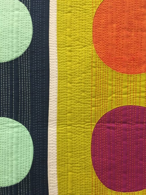 detail of “Eclectic Slide” by Stephanie Z. Ruyle @spontaneousthreads Statement: “This small quilt maximizes its design aesthetic by using the quilt top, the quilt binding and the quilting. Colorful, bold shapes, multicolored heavy weight thread and a pieced binding all lend to its cohesive visual impact.” Modern quilt featured in the Small Quilts category at QuiltCon 2020 in Austin, Texas presented by the Modern Quilt Guild.