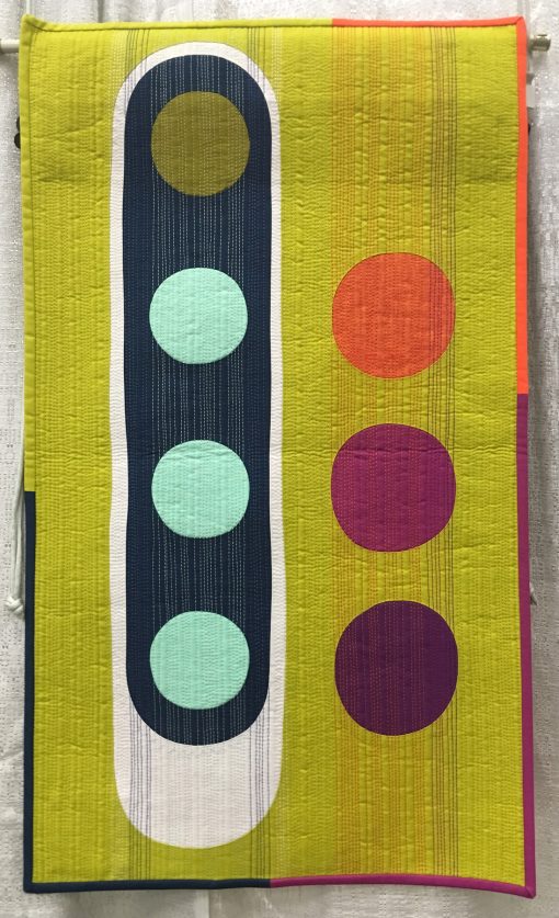 “Eclectic Slide” by Stephanie Z. Ruyle @spontaneousthreads Statement: “This small quilt maximizes its design aesthetic by using the quilt top, the quilt binding and the quilting. Colorful, bold shapes, multicolored heavy weight thread and a pieced binding all lend to its cohesive visual impact.” Modern quilt featured in the Small Quilts category at QuiltCon 2020 in Austin, Texas presented by the Modern Quilt Guild.