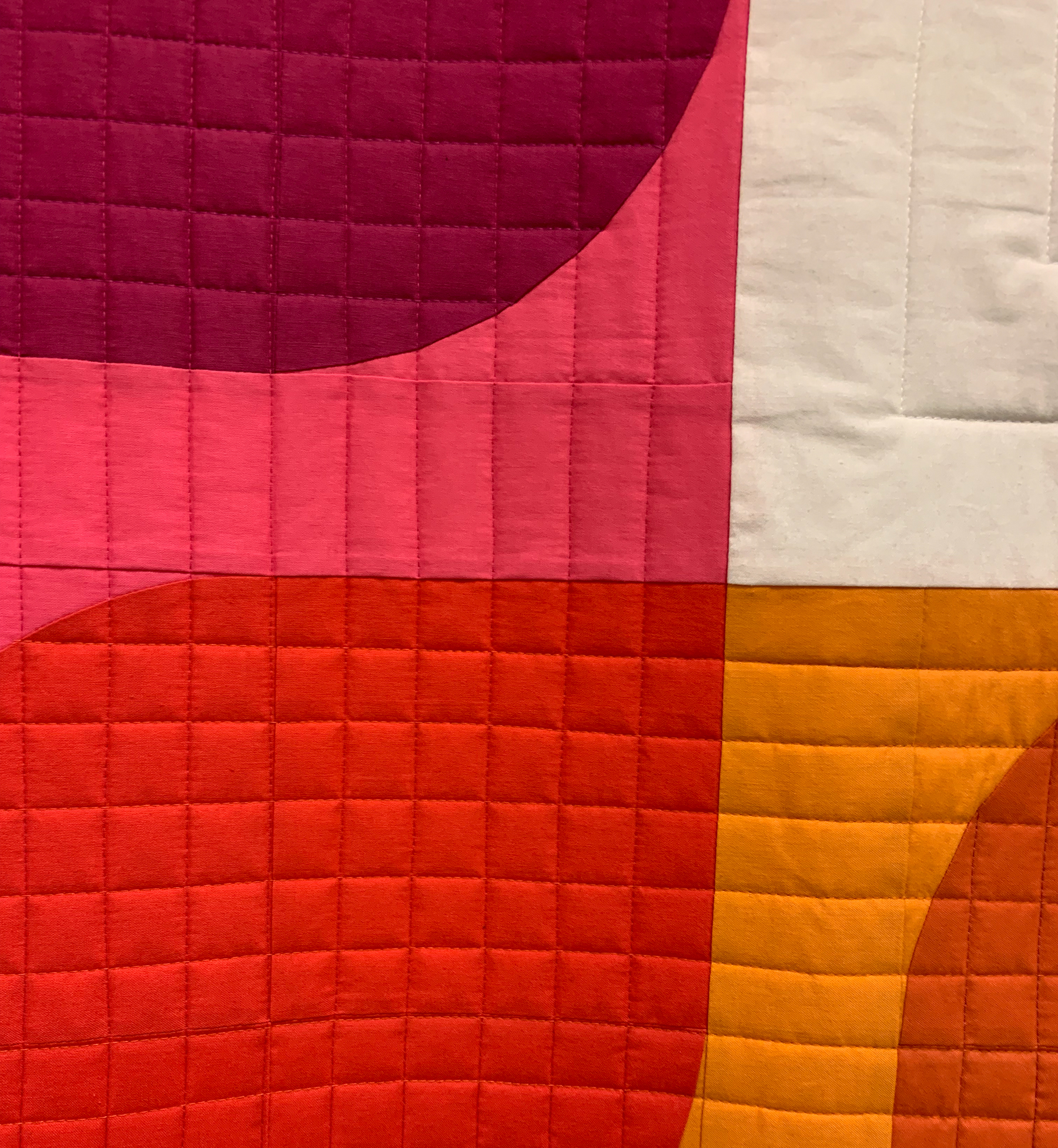 detail of modern quilt with warm colors and curves
