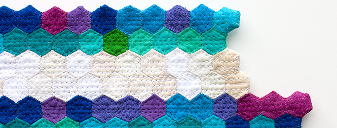 detail of miniature color quilt made out of tiny hexagons