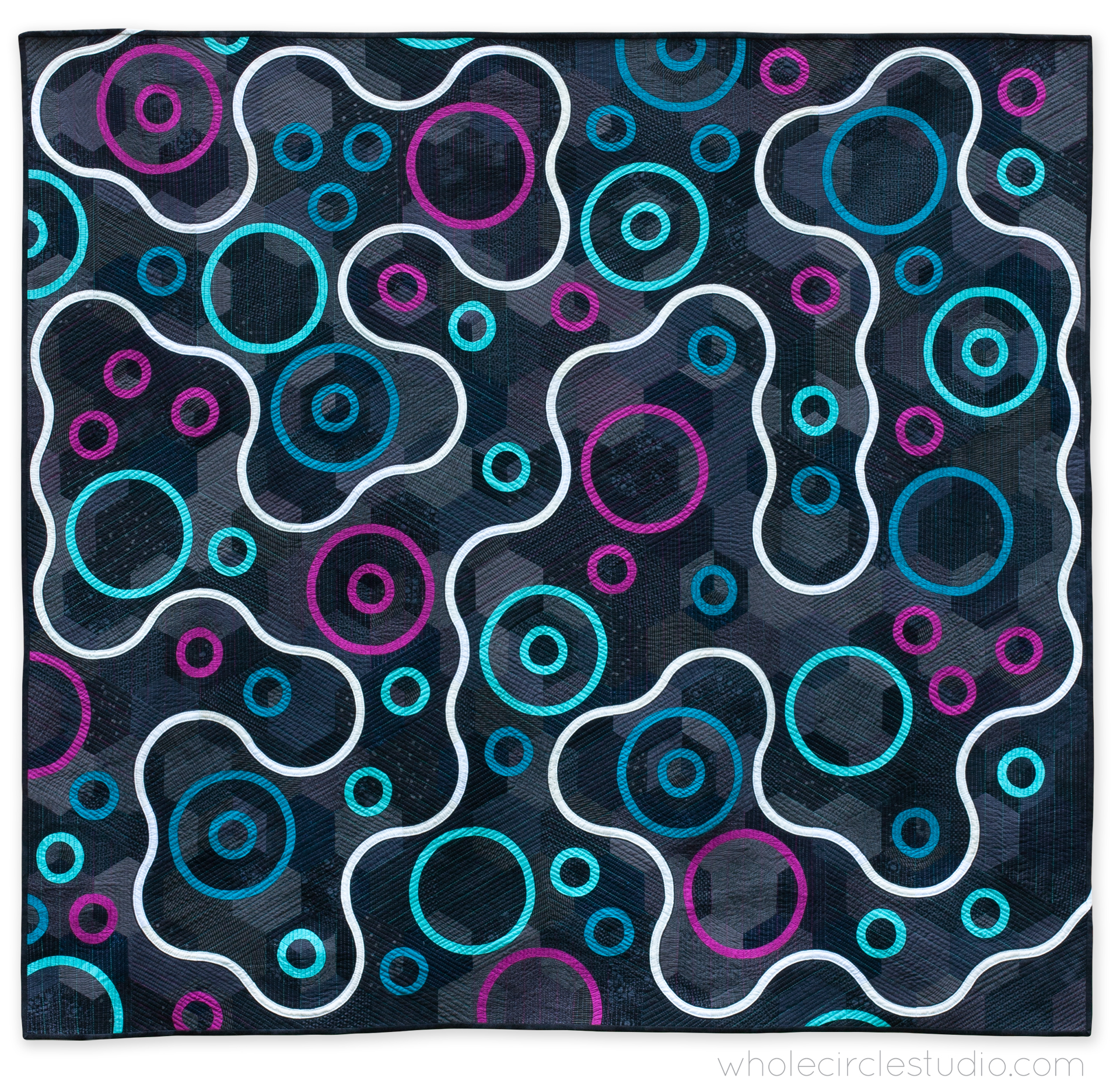 modern minimalist quilt with a dark background and a white curvy line moving around magenta, blue, and aqua circles