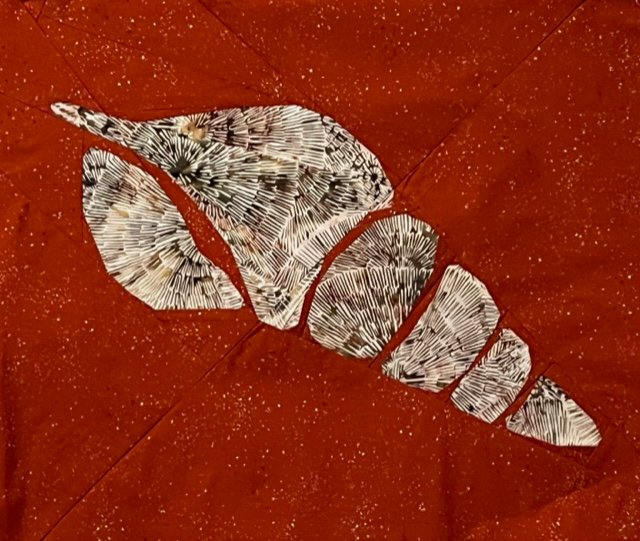 quilt block of an abstract Tulip Shell. Brown textured shell on a rusty red background