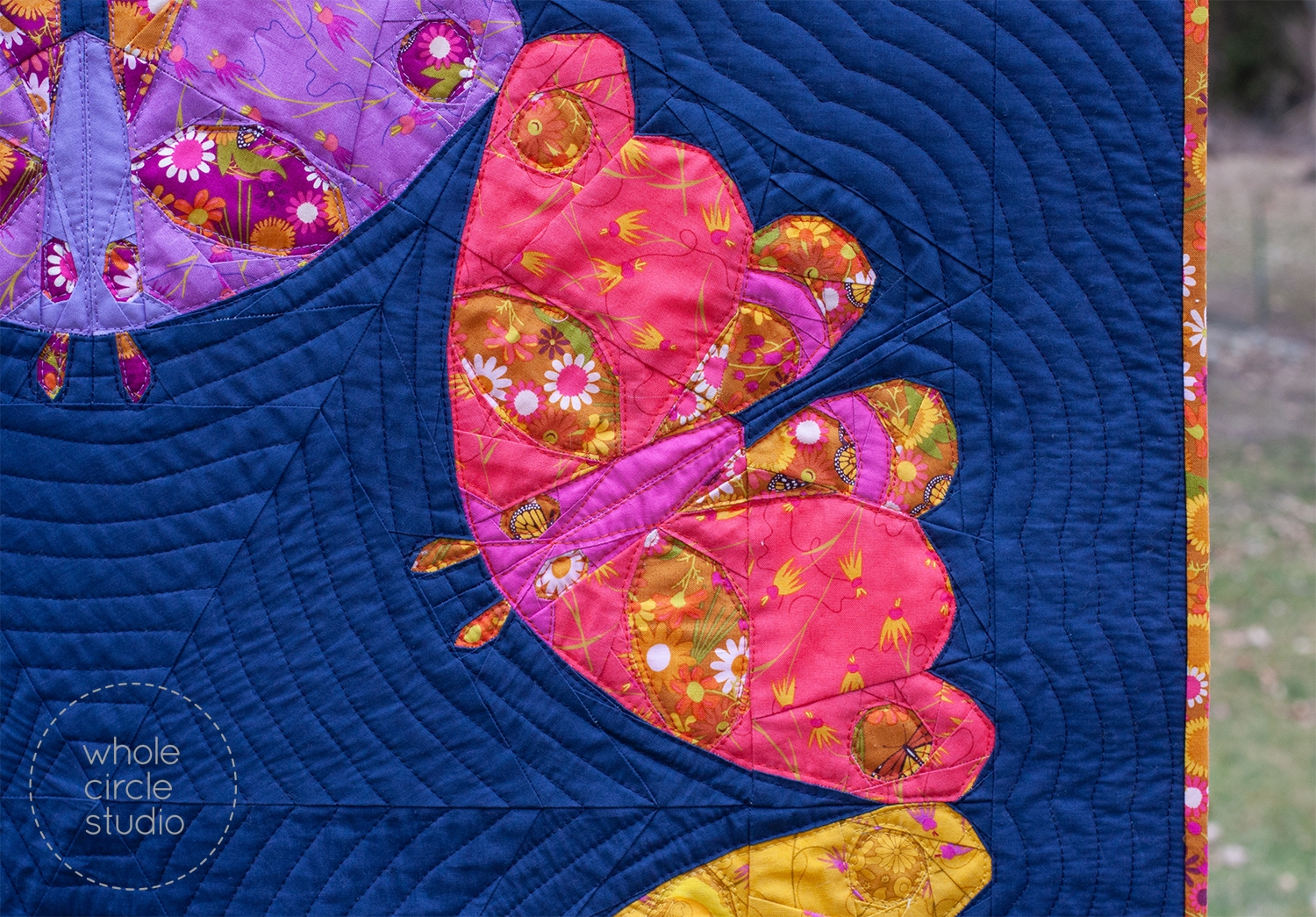 detail of a quilt with 6 moths in a circle