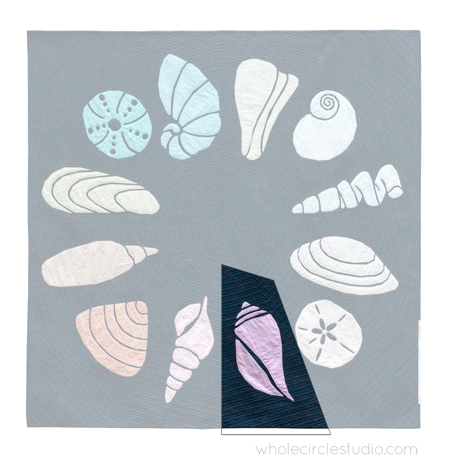 quilt of 12 abstract sea shells in a circle with one block of lightening welk shell highlighted