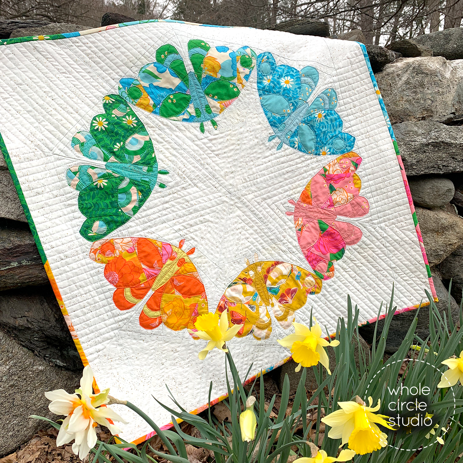 quilt that has 6 colorful moths arranged in a circle.