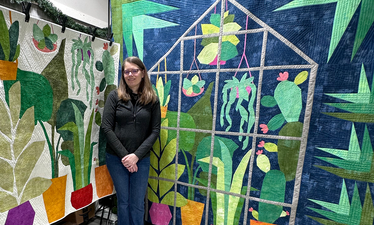 woman standing in front of two quilts