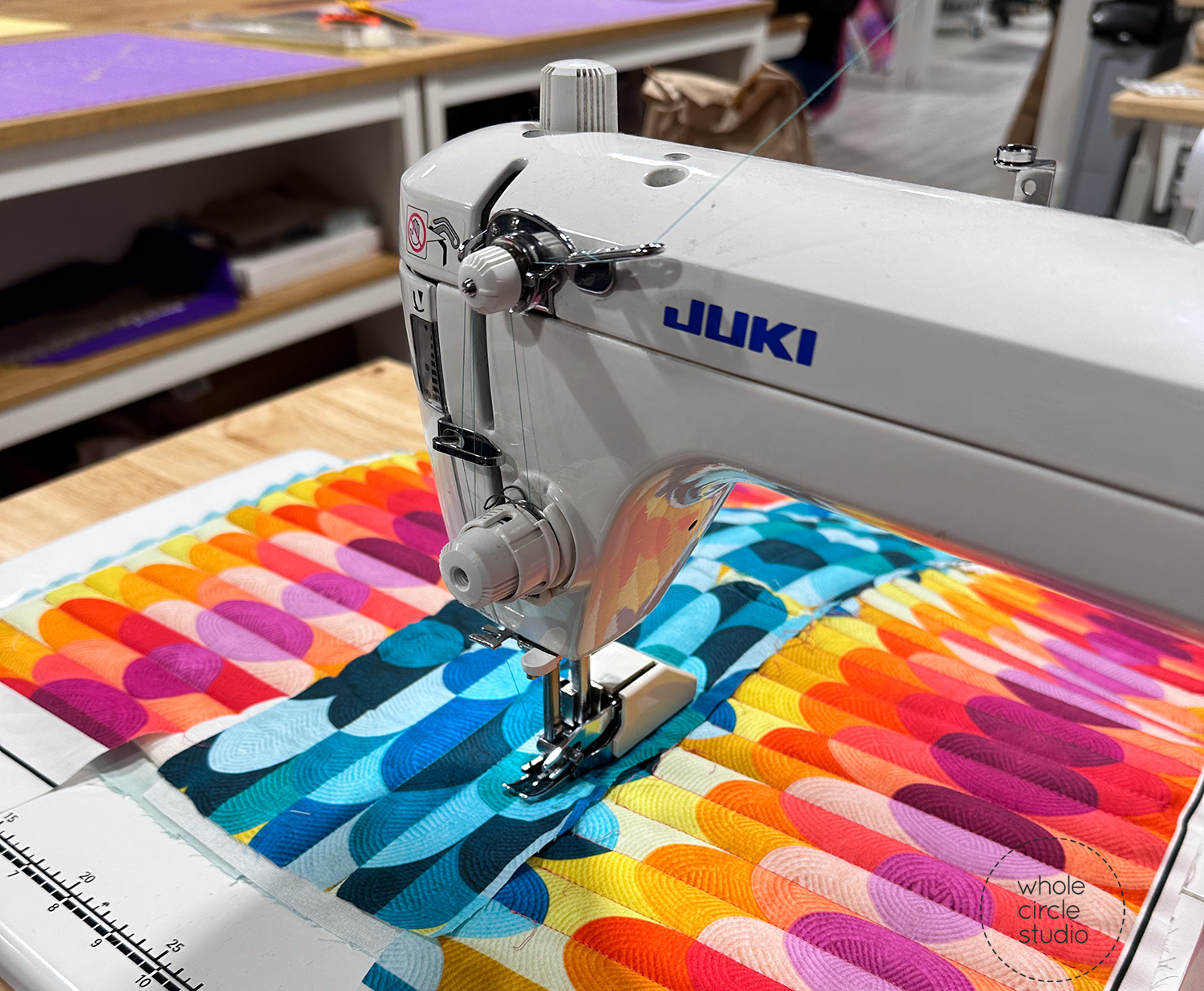 bright colorful fabric being quilted on a sewing machine
