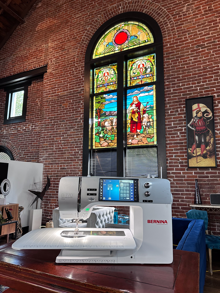 sewing machine in front of a stained glass window