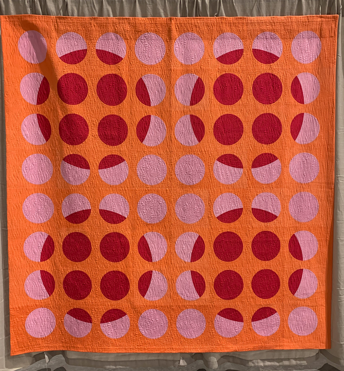modern quilt: red, pink, and orange quilt with lots of circles