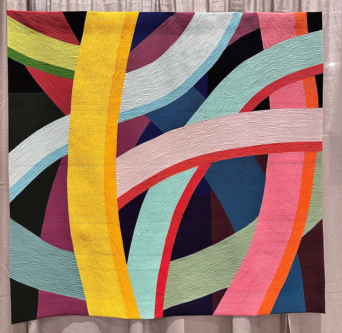 detail of colorful quilt with large gentle curves