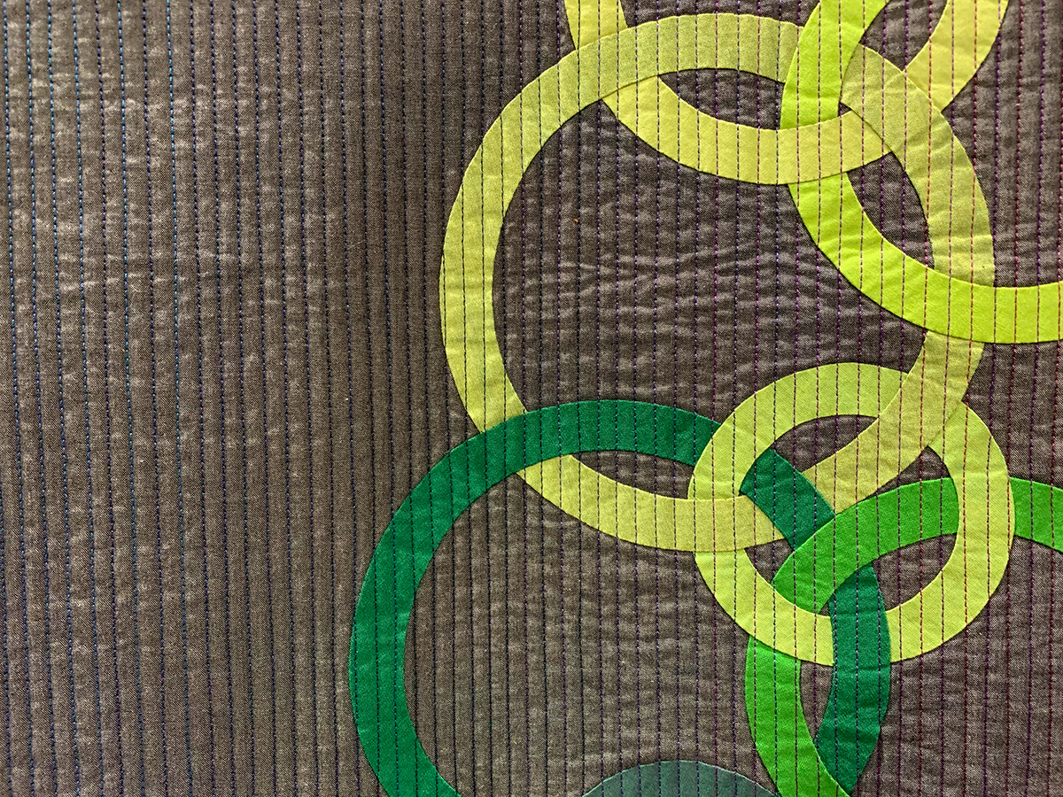 detail of colorful quilt of circles in a square arrangment