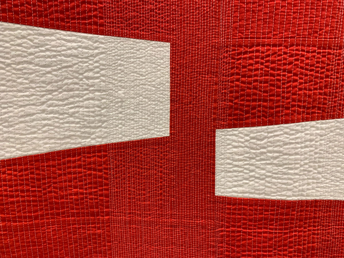detail of geometric quilt, red and white