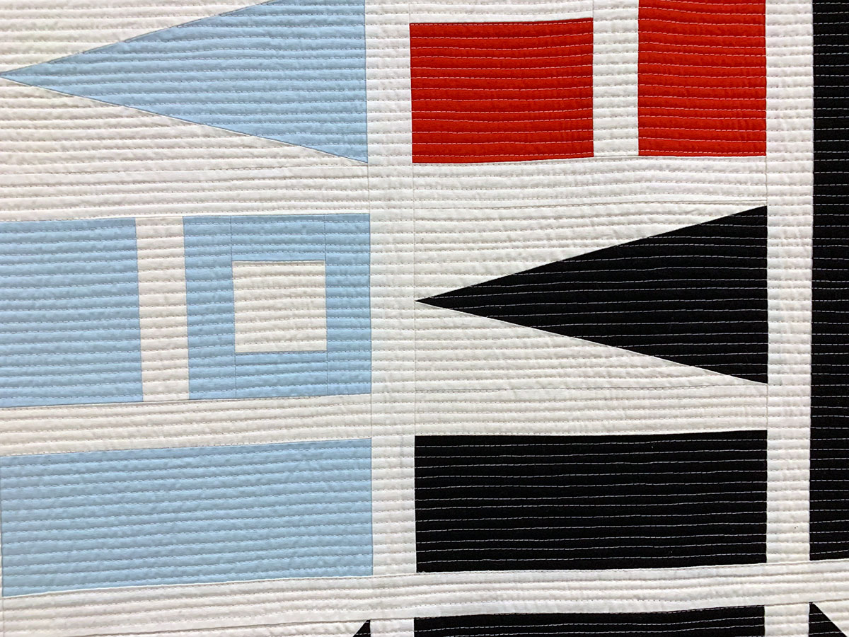 detail of geometric quilt: blue, white, black and red