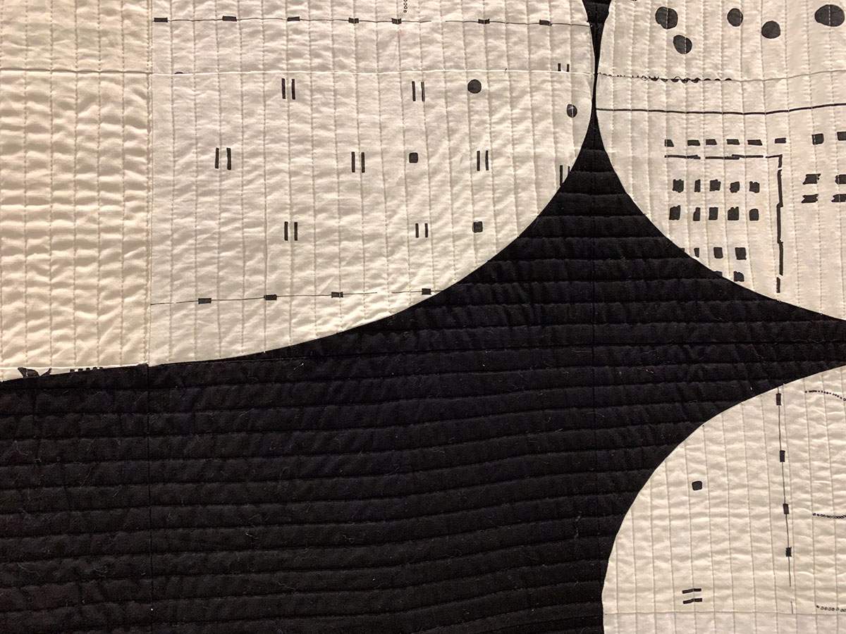 detail of abstract quilt, black and white with red