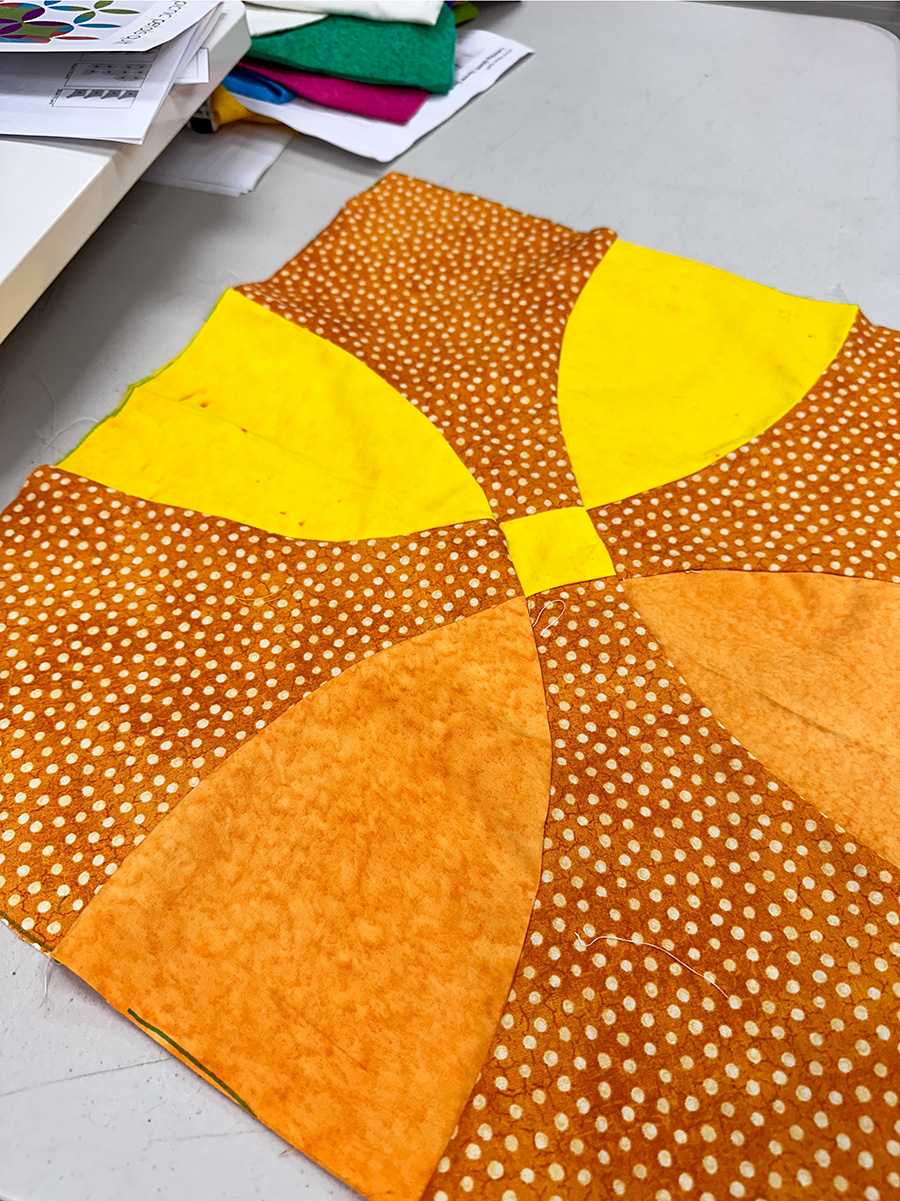 a yellow and orange curved quilt block