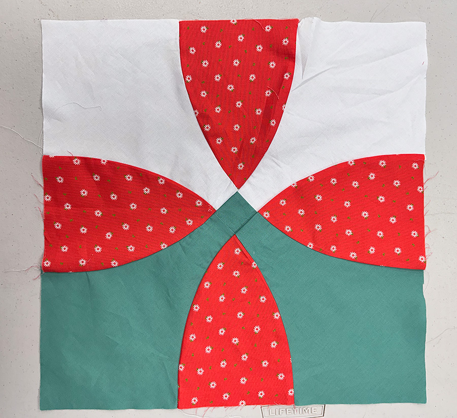 an orange, white and green curved quilt block