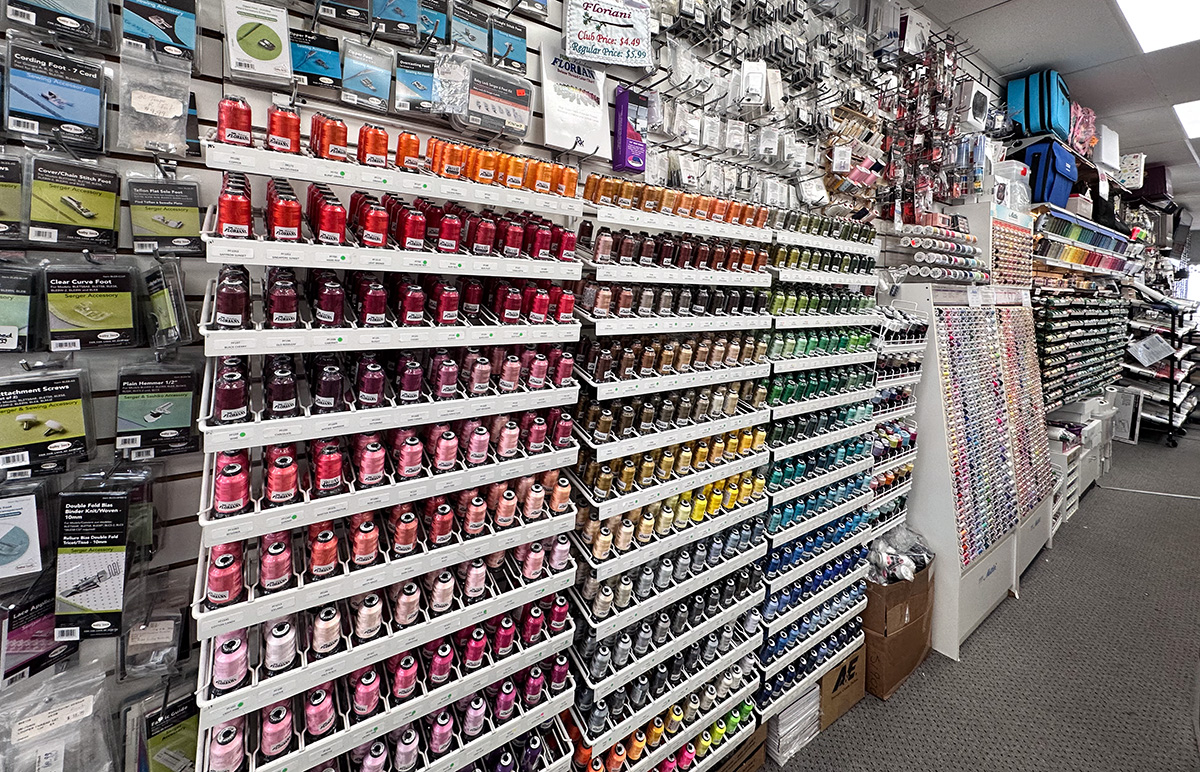 a display of colorful thread and sewing machine accessories at a sewing machine shop