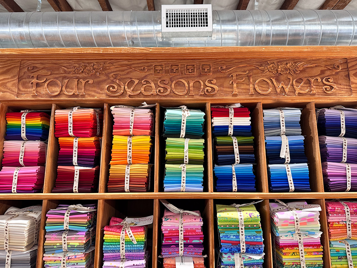 bundles of colorful fabric in a wooden display