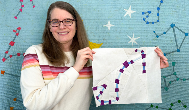 woman holding a Scorpio zodiac star zodiac star quilt block