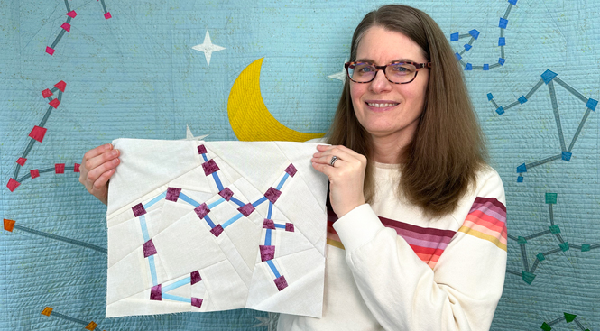 woman holding a Sagittarius zodiac star zodiac star quilt block