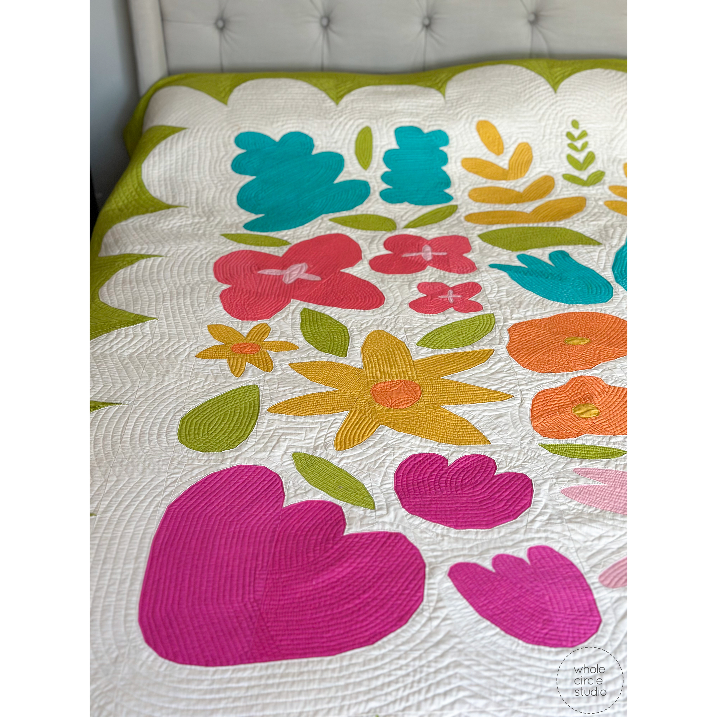close up of bright, bold flower quilt on a bed