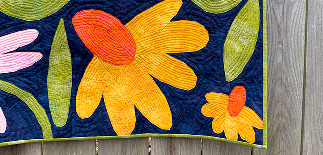 corner of a large yellow and orange flower quilt