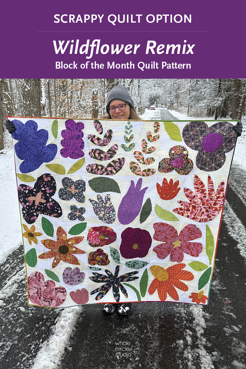 modern scrappy flower quilt being held by a woman on a snowy road