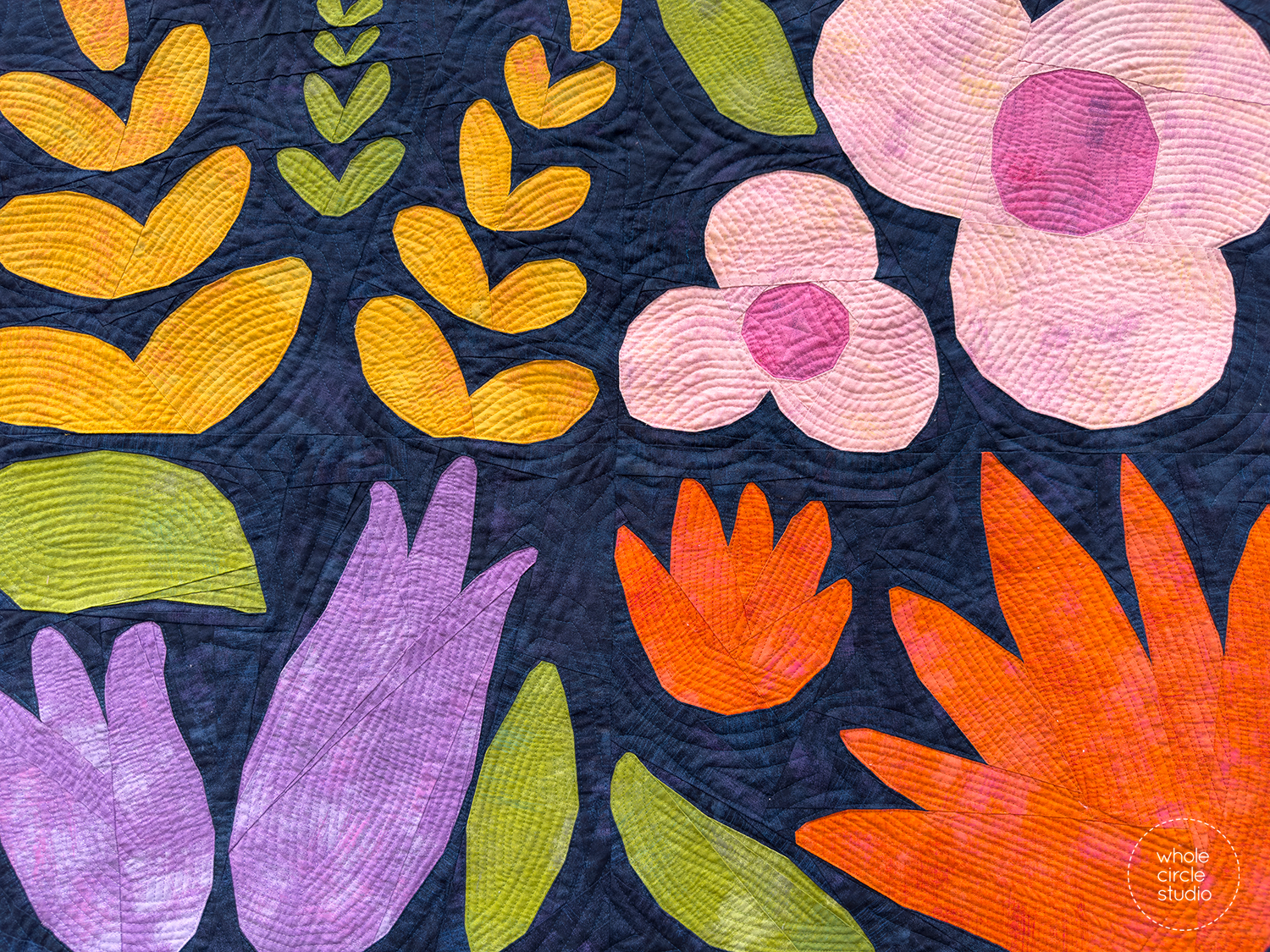 close up of colorful flower quilt blocks on a navy background against a wooden fence