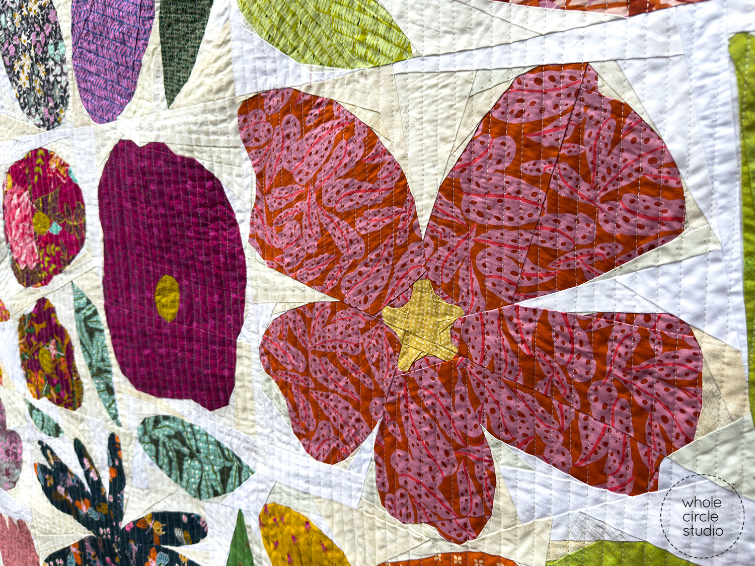 close up of modern quilt made with floral fabrics on a scrappy fabric background