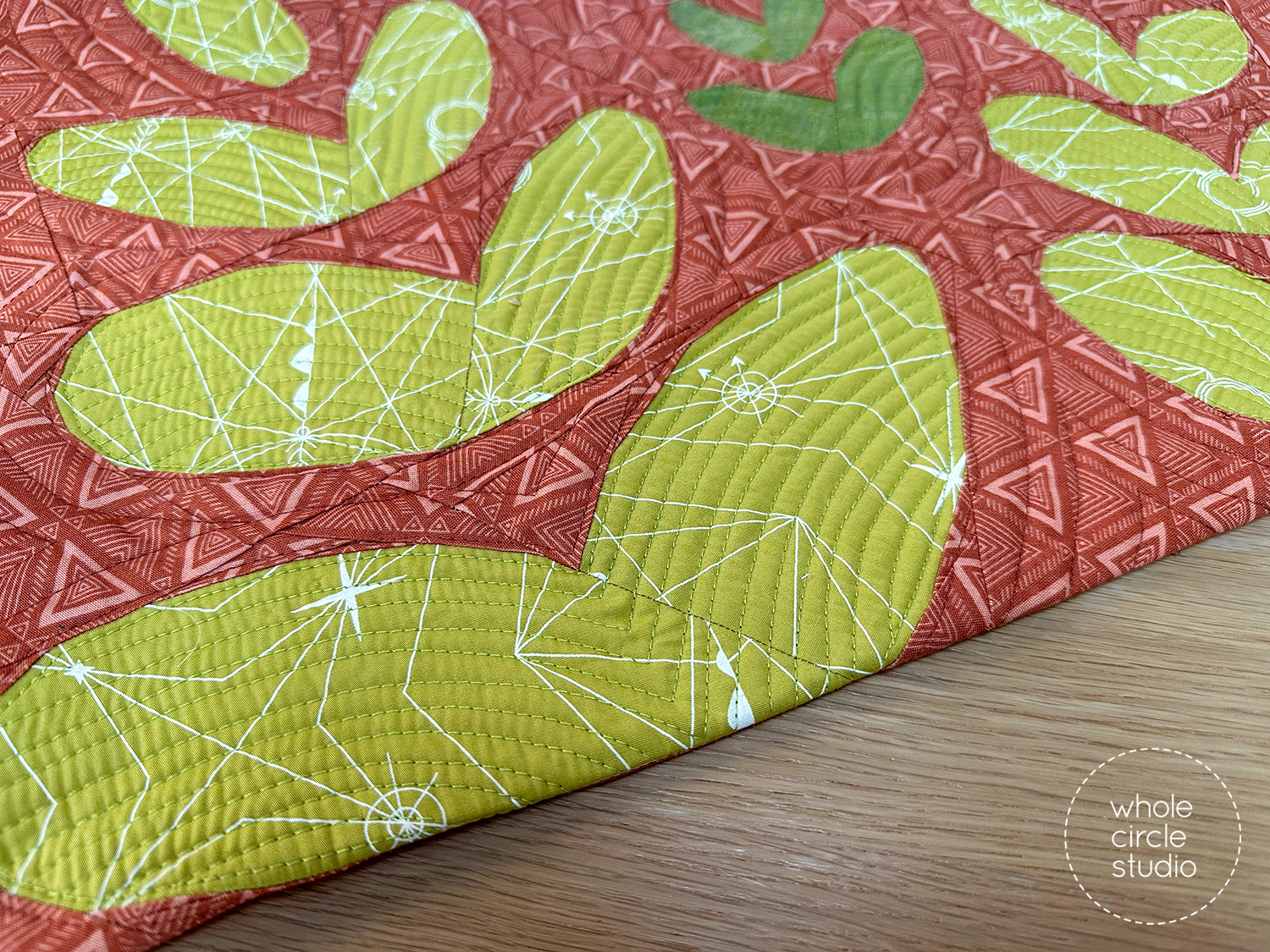 Detail of a Wildflower Remix placemat showing a foundation paper pieced flower block made green and tan fabrics