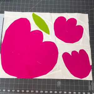 flower quilt block made with solid fabric sitting on a cutting mat