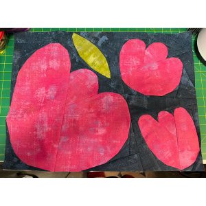 paper pieced flower quilt block on a cutting mat