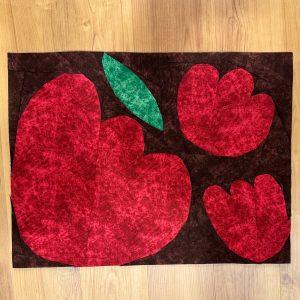 flower quilt block made with red, green, and brown fabric