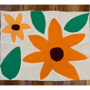 orange and yellow flower quilt block on a wood floor
