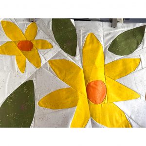 Paper pieced flower quilt block on a neutral background