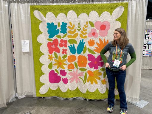 woman looking at modern colorful flower quilt